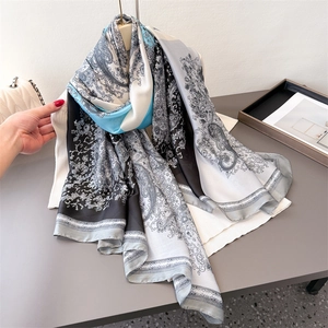 Eleganter Paisley-Seidenschal mit blau-schwarzen Mustern, der Fall und Textur zeigt