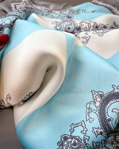 Detail eines Seidenschals mit himmelblauen Streifen und schwarzem Paisle Paisley-Muster