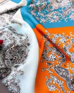 Detail eines Vintage-Paisleymusters auf einem seidigen Satinschal mit kräftigen Farben