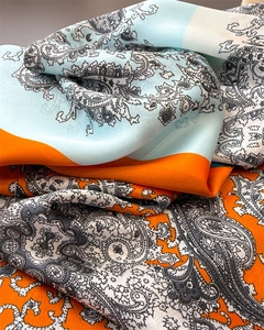 Detailansicht der Seidenschal-Textur mit Paisley-Muster in Orange und Blau