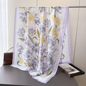 Detail of silk satin scarf featuring elegant purple tulip floral patterns and soft fabric