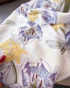 Detailed close-up of floral print silk scarf featuring purple and yellow blossoms