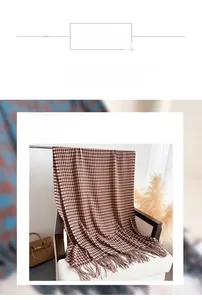 Detailed close-up of houndstooth scarf texture with fringe trim and polyester fiber label