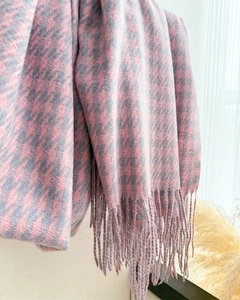 Close-up of pink and grey houndstooth scarf texture with delicate fringe tassel details