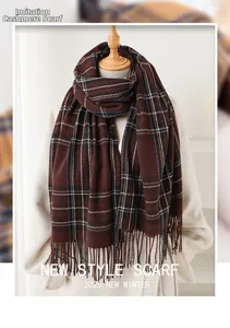 Detail of the soft cashmere-feel fabric and fringes on the dark brown plaid scarf