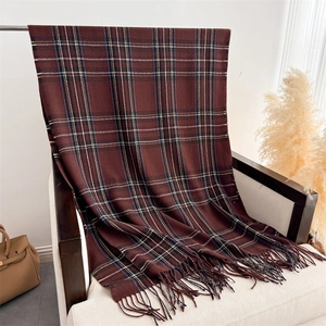 Close-up of vintage brown plaid cashmere scarf with tassel details on a wooden chair