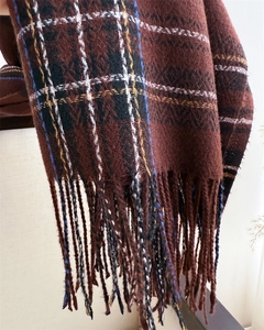 Close-up of deep brown plaid scarf featuring soft cashmere-like texture and fringed edges