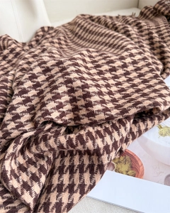 Close-up of houndstooth cashmere shawl showing soft knit texture and fringe details