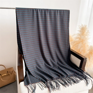 Classic houndstooth scarf with tassels in navy and burgundy draped on a chair
