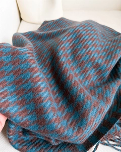 Detailed view of dark blue houndstooth scarf texture with soft fringe edges