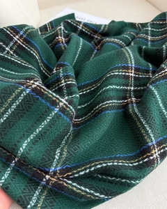 Detailed macro view of dark green plaid fabric showing thick twill weave texture