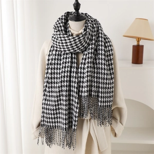 Classic black and white houndstooth long scarf with fringes styled on a beige wool coat