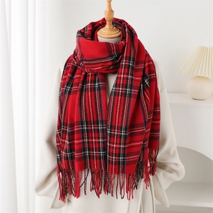 Classic red plaid cashmere-feel scarf with tassels worn over a white winter coat