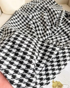 Macro shot of thick black and white houndstooth wool fabric texture for winter scarf