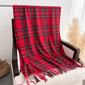 Detailed close-up of red and black plaid cashmere-feel scarf with long handmade tassels