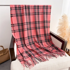 Detail of pink and black plaid scarf texture with soft fringe edges on white chair