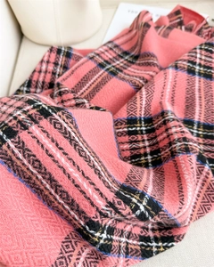 Detail of pink plaid scarf showing soft cashmere-like texture and geometric knit patterns