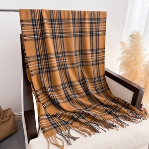 Macro detail of ginger plaid scarf texture and fringe on white vintage chair