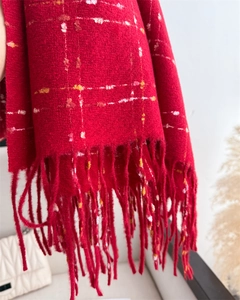 Detail showing red plaid scarf fringe and soft cashmere-like knit texture