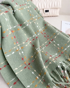 Close-up of light green plaid scarf with red and orange stripes and fringe details