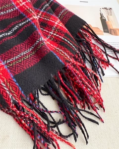 Close-up of red and black plaid scarf texture with dense colorful fringe detail