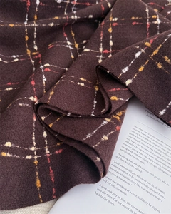 Detail of dark brown plaid cashmere-like fabric with soft brushed texture and fringe