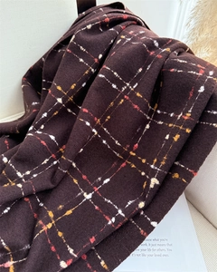 Close-up of soft dark brown plaid cashmere-like scarf with fringe on a chair