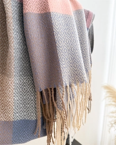 Detail of soft plaid scarf with fringe trim showing texture of knit diamond pattern