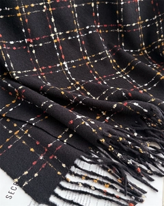 Close-up of black plaid cashmere scarf with colorful fine stripes and fringe details