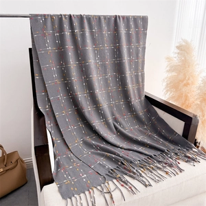 Close-up of grey scarf with colorful dotted grid pattern and soft long fringe texture