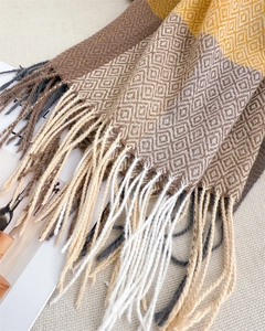 Macro shot of geometric diamond patterns and soft tassels on earth-tone cashmere scarf