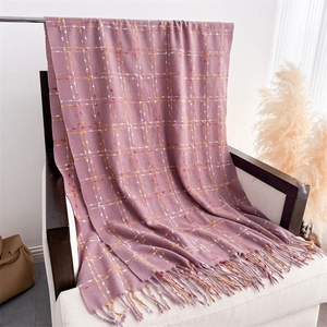 Detail of purple plaid scarf with fine fringe texture draped on white wooden chair