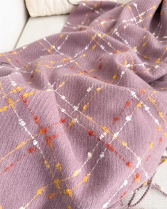 Detail of lilac plaid cashmere scarf featuring thick twill weave and tassel accents