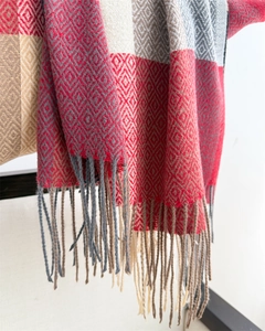 Detail of multi-color diamond lattice knit scarf with elegant fringe tassels for autumn