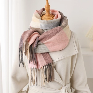 Detail of pink and grey checkered plaid scarf with soft fringe on a white coat