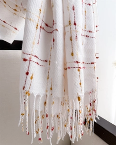 Close-up of beige pashmina scarf featuring colorful thin stripes and long tassel fringe details