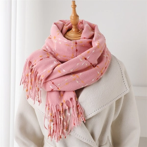 Pink plaid cashmere scarf with tassels styled over a white coat for winter fashion