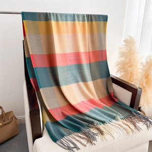 Close-up of colorful checkered scarf with long tassels draped on a chair