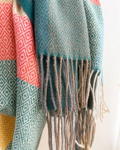 Detailed view of colorful geometric diamond pattern with soft fringe on long scarf