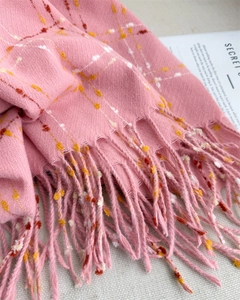 Close-up of pink cashmere-like scarf showing colorful speckles and soft fringe detail