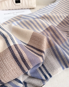 Detailed view of the soft cashmere-like texture and striped plaid pattern of the winter scarf