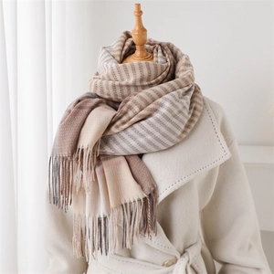 Close-up of earth-tone striped scarf with soft tassels on a beige winter coat