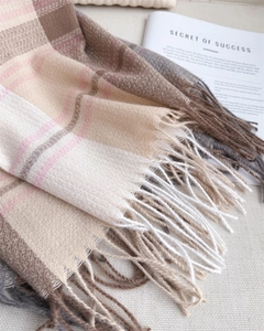 Close-up of soft beige and brown striped scarf with elegant tassels and knit texture
