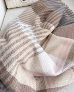 Detailed close-up of thick striped cashmere scarf fabric with soft tassels and woven texture