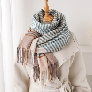 Elegant blue and beige striped cashmere-like long scarf with tassels on white coat