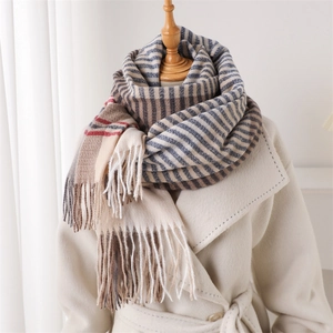 Elegant color-block striped scarf with tassels shown on a beige wool coat display