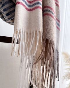 Close-up of soft cashmere scarf texture with blue stripes and elegant fringe details