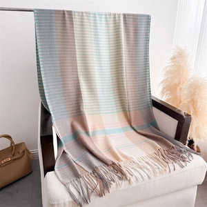 Detail of color-block striped long scarf with fringe on a cozy fabric chair