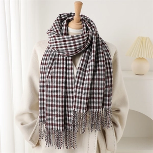 Classic red plaid long scarf with tassels on a mannequin in a cozy indoor setting