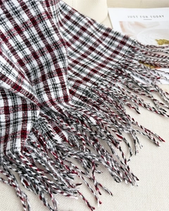 Detail of red and black plaid scarf texture and handmade tassel fringe craftsmanship